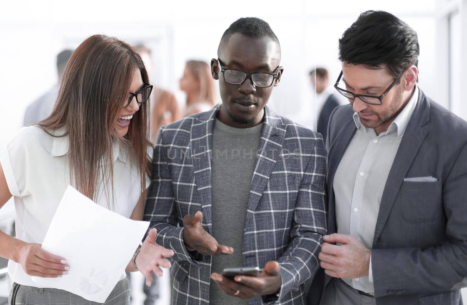 three colleagues looking at the smartphone screen.people and technology