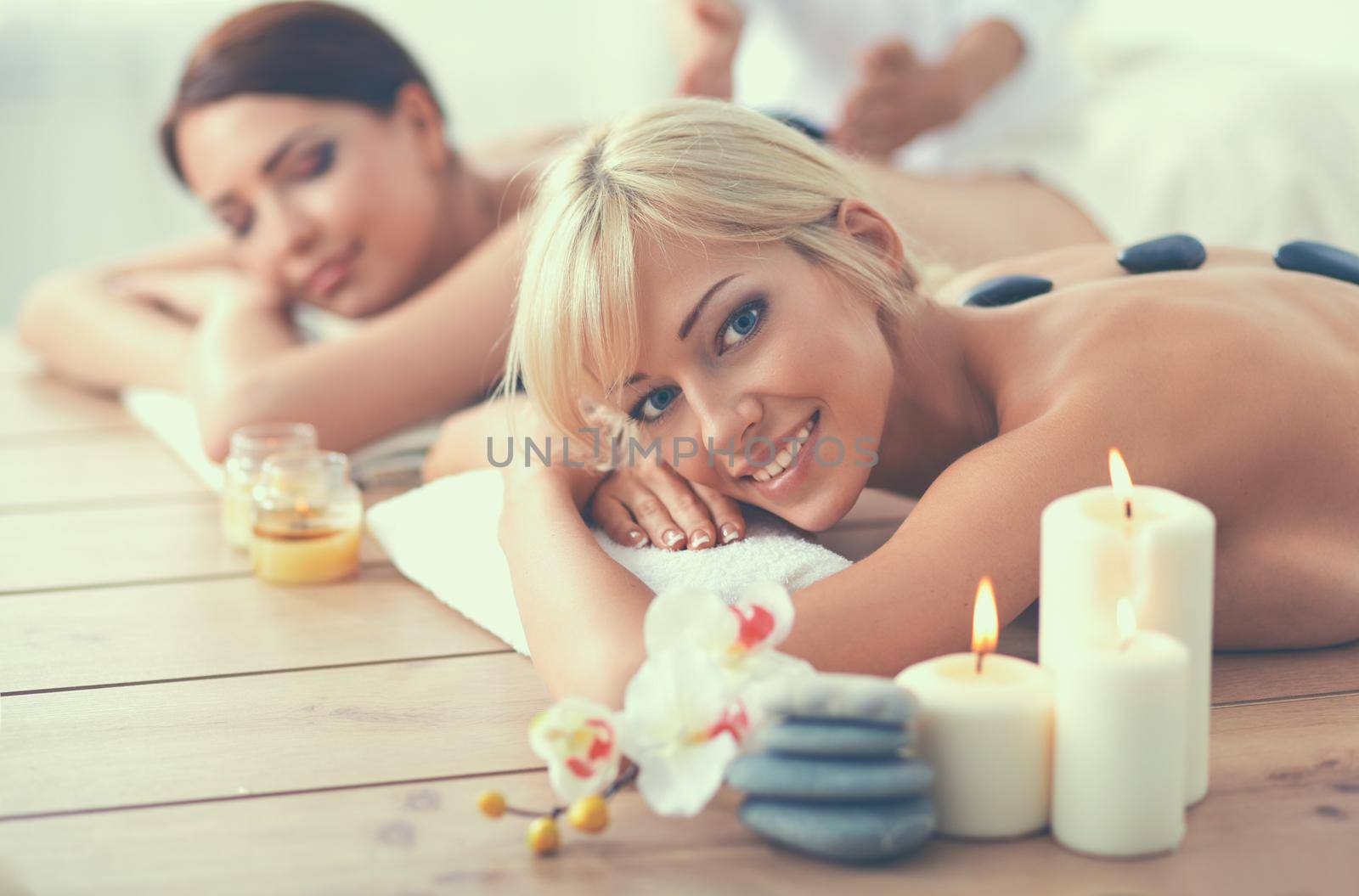 Two young beautiful women relaxing and enjoying at the spa cent.