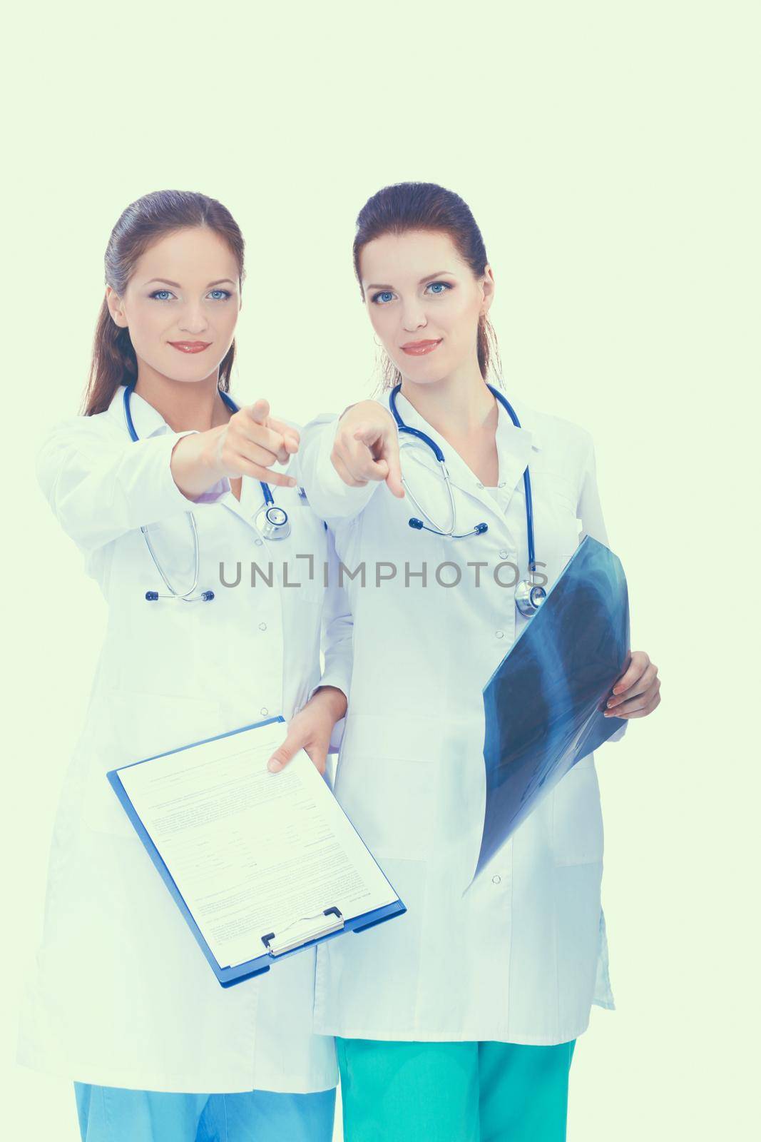 Two woman nurse watching X Ray image, standing in hospital, pointing you.