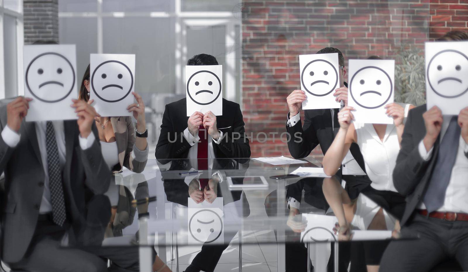 group of business people with smiley icons sitting at their Desk by asdf