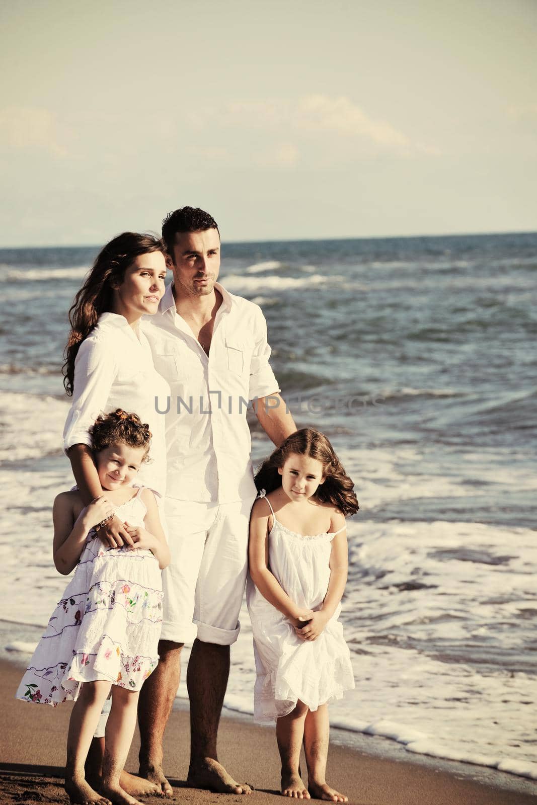 happy young family in white clothing have fun at vacations on beautiful beach 