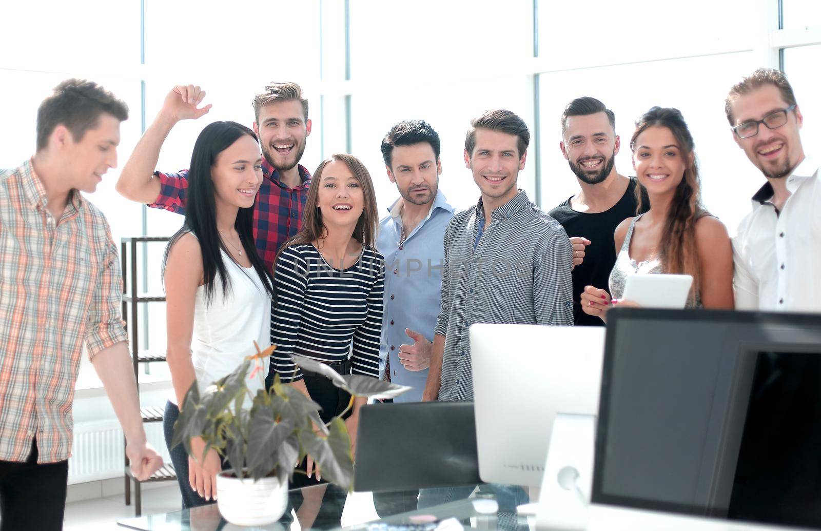 happy business team standing in new office by asdf