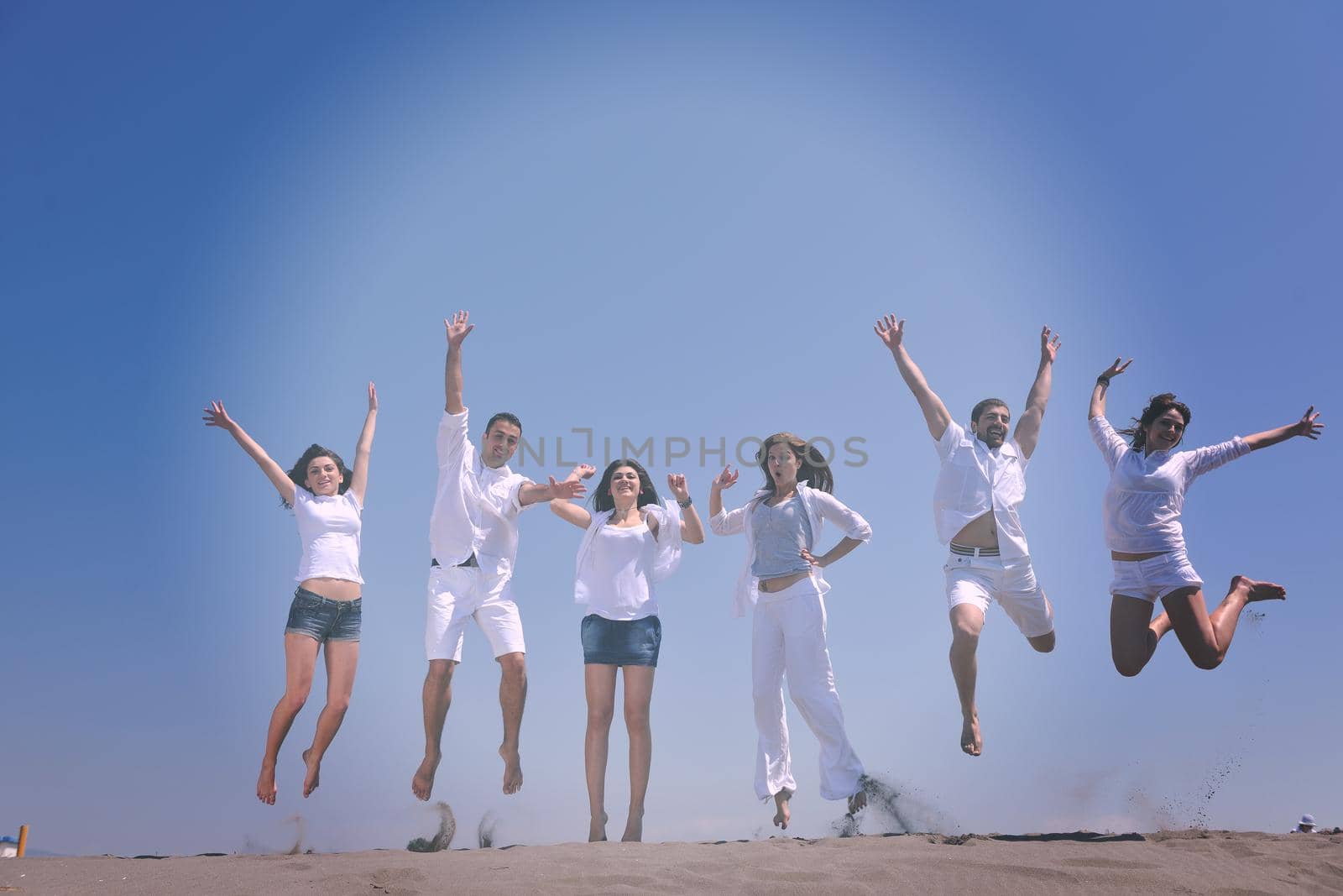 happy people group have fun  run and jump  on beach beautiful sand  beach