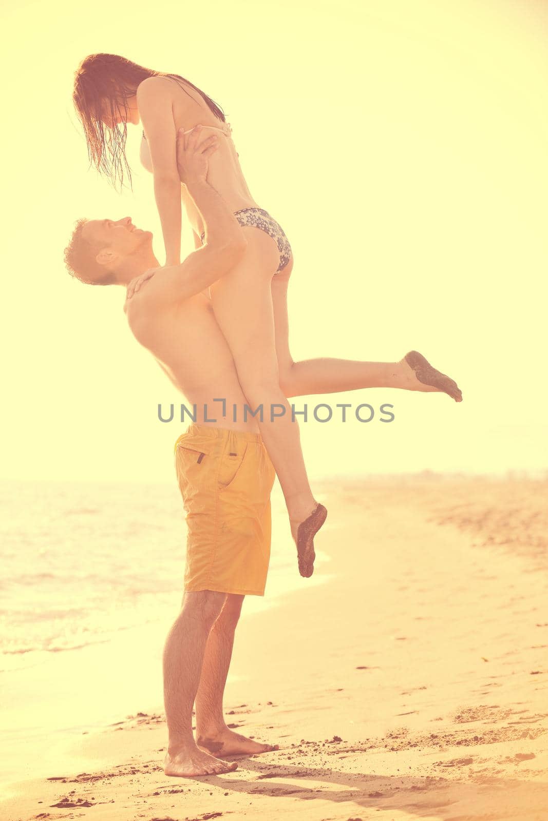 happy young couple have romantic time on beach at sunset