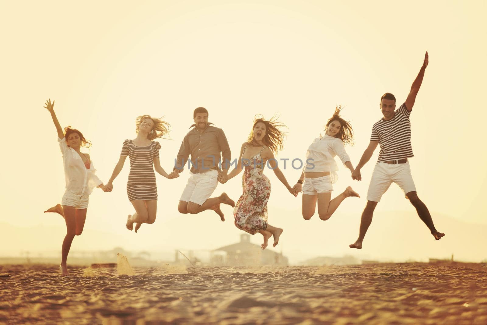 happy young  people group have fun on beach by dotshock