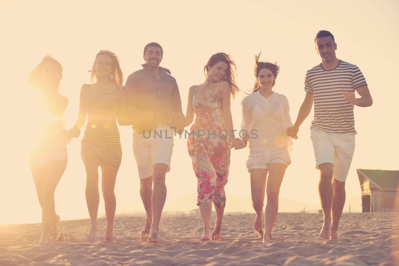 happy young  people group have fun on beach by dotshock