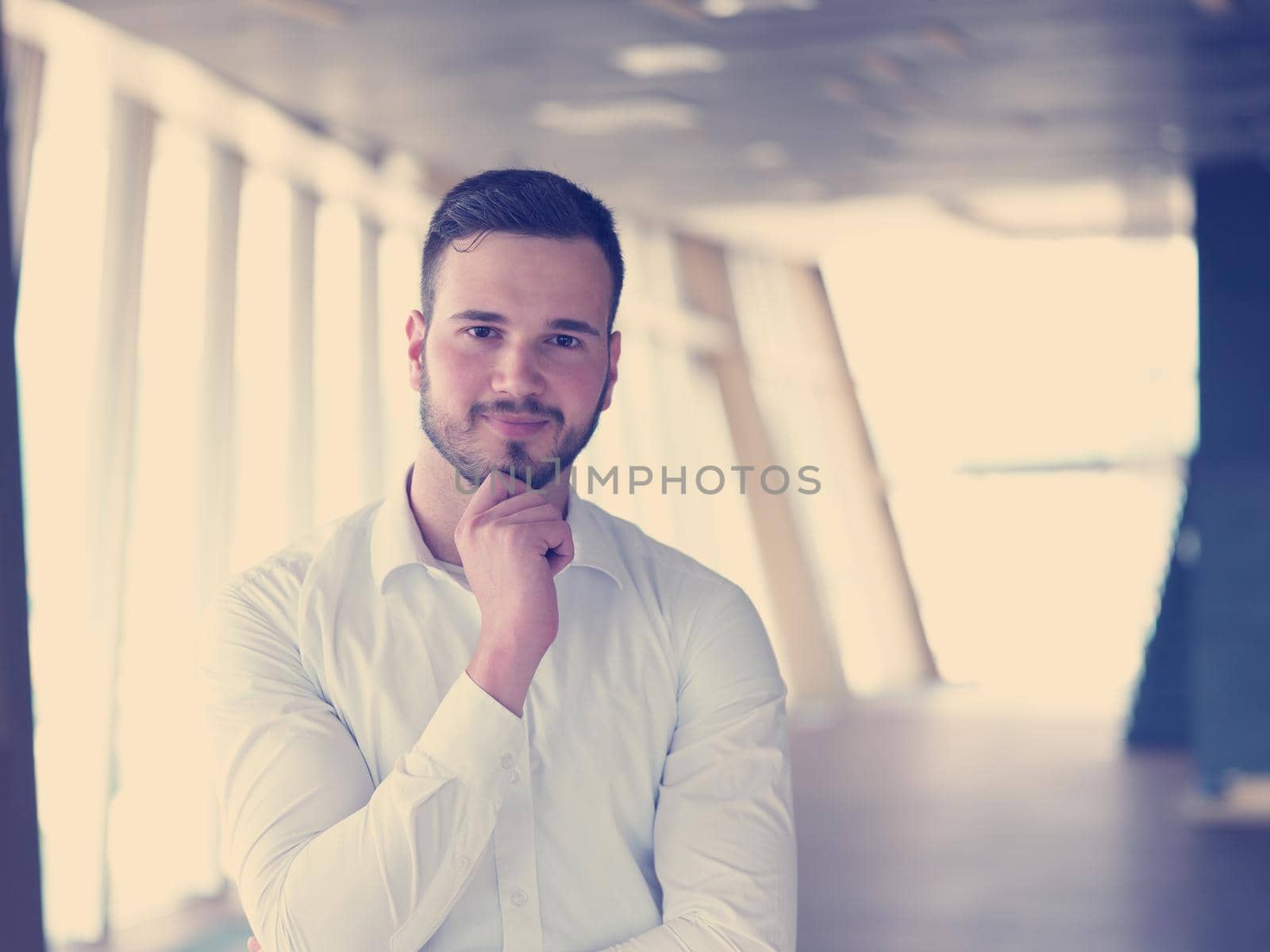 portrait of young handsome hipster business man with beard at modern office space interior