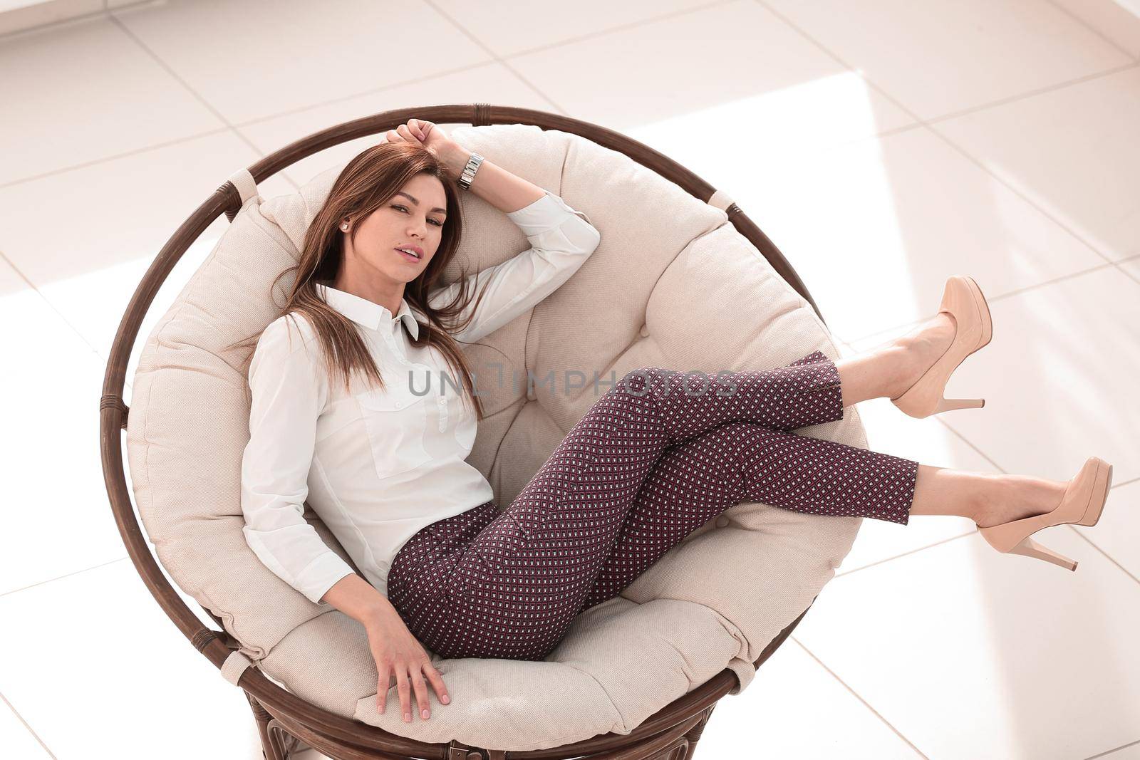 tired young woman resting in a soft round chair by asdf