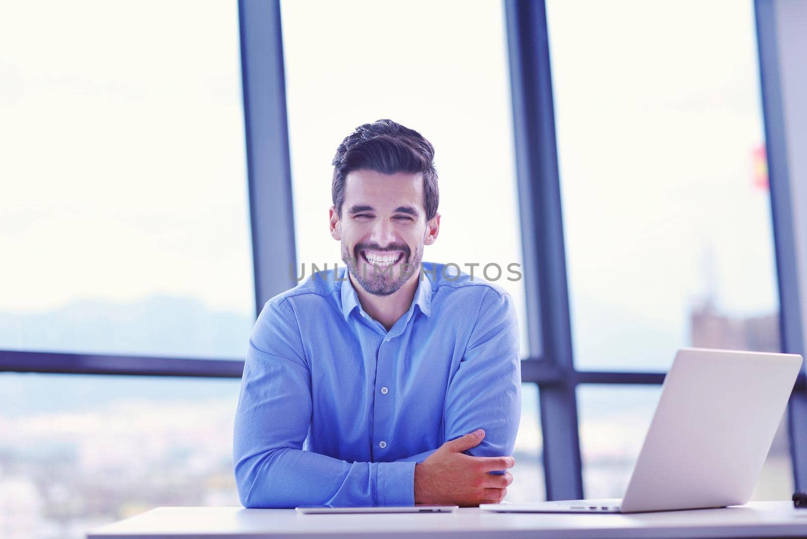 happy young business man at office by dotshock