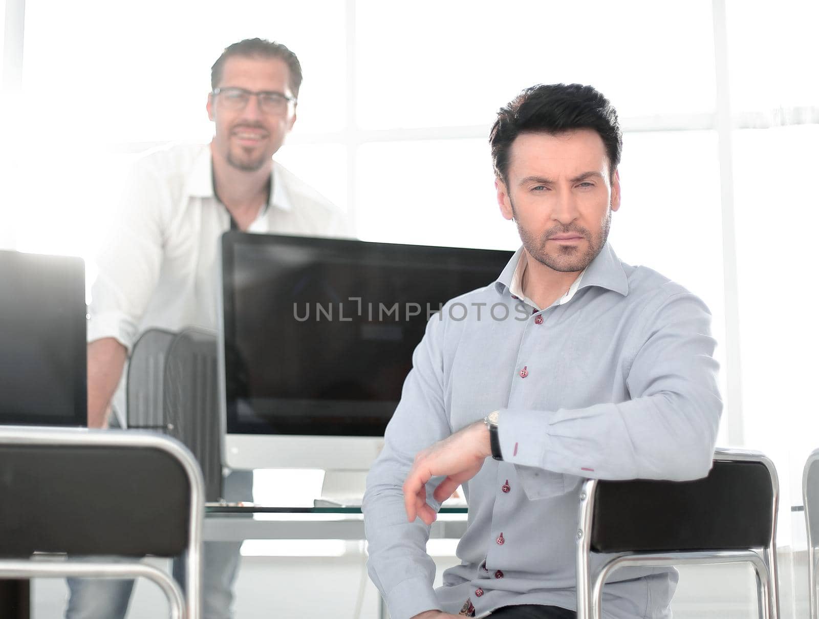 confident businessman sitting at a computer table by asdf