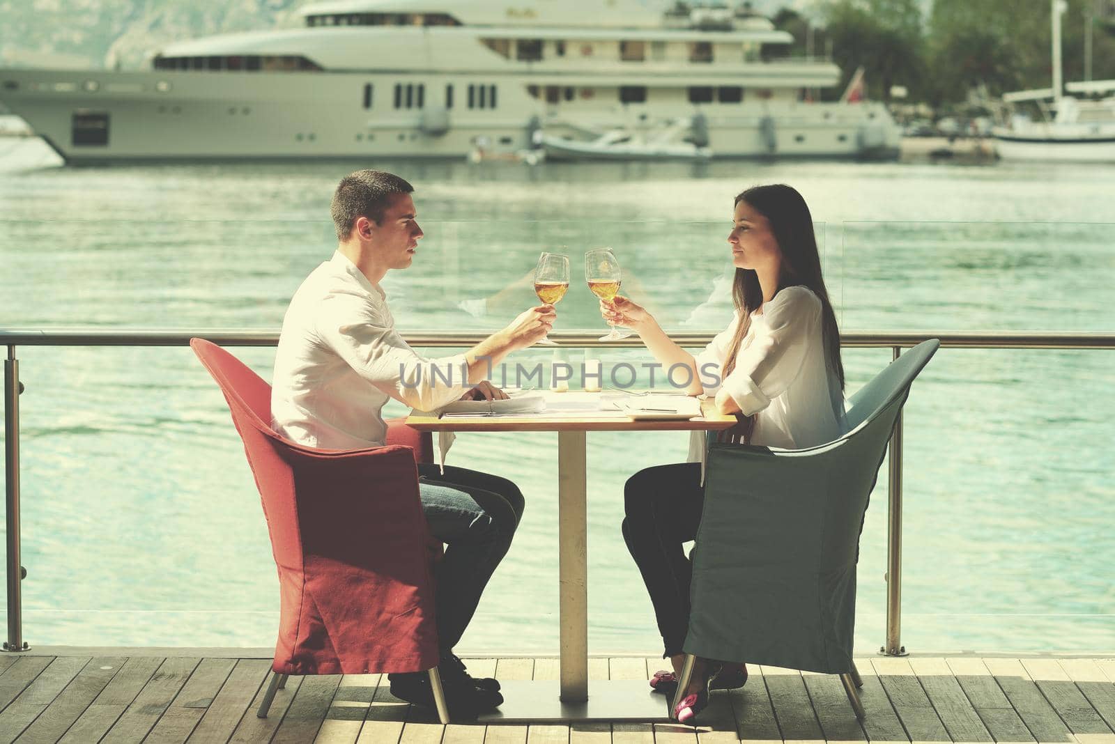 happy young couple having lanch at beautiful restaurant on by the sea on  beach