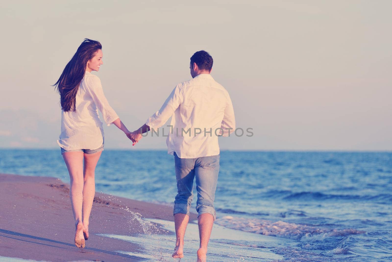 happy young romantic couple in love have fun on beautiful beach at beautiful summer day