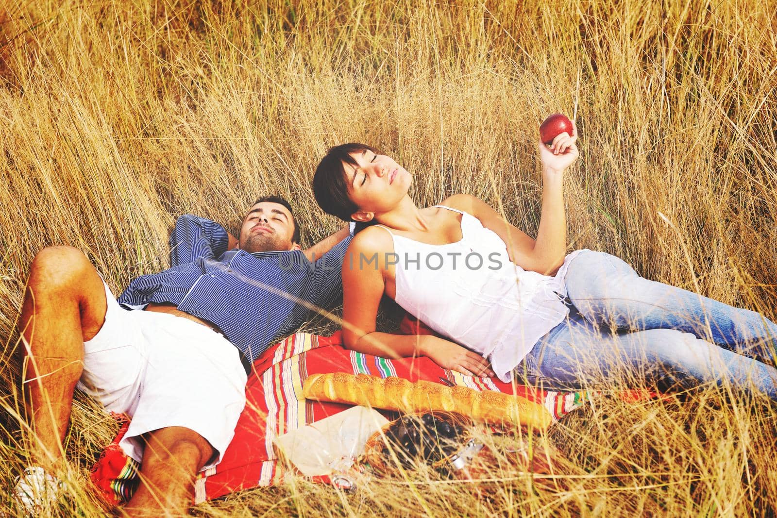 happy young couple enjoying  picnic on the countryside in the field  and have good time