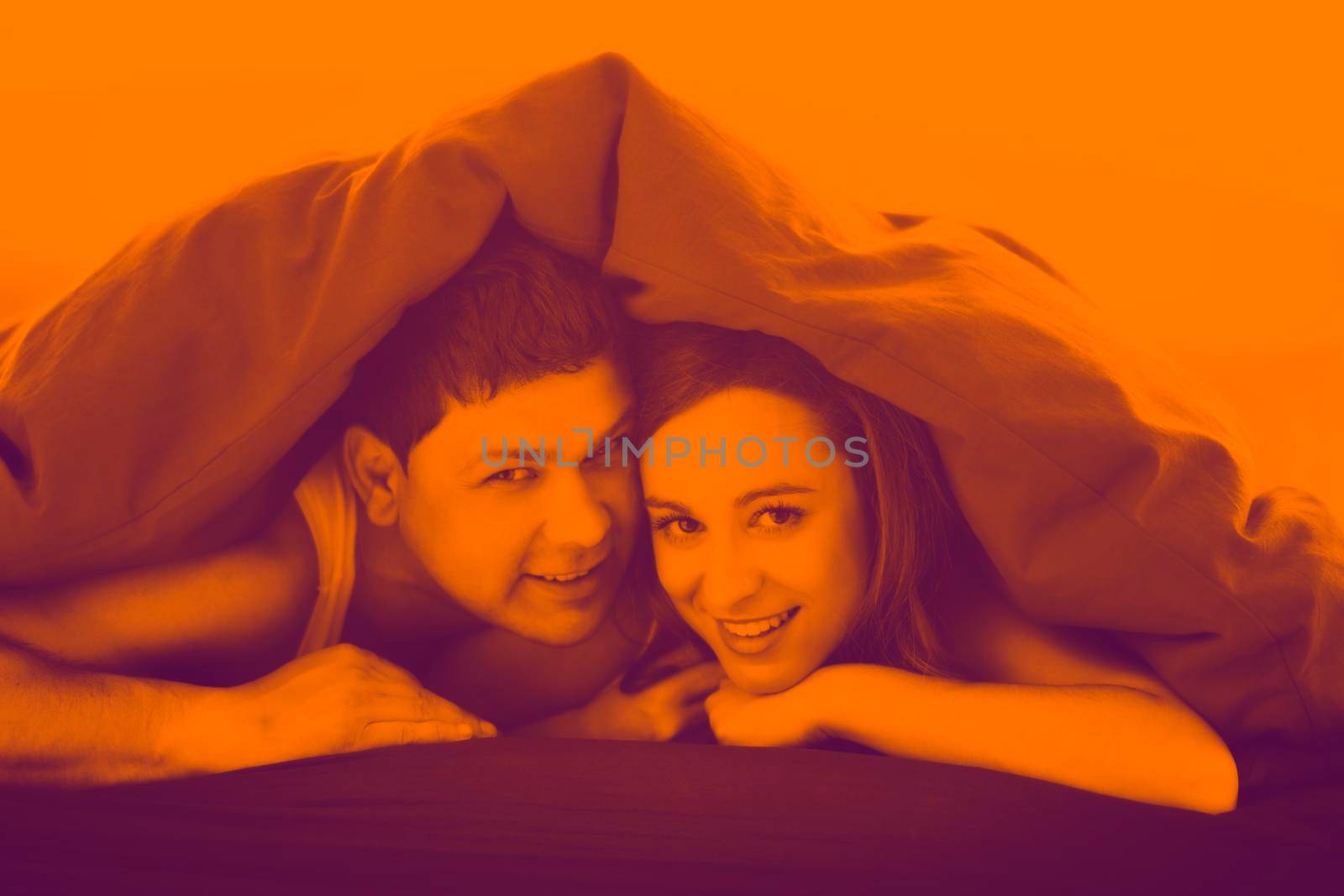 happy young couple in bed at morning duo tone
