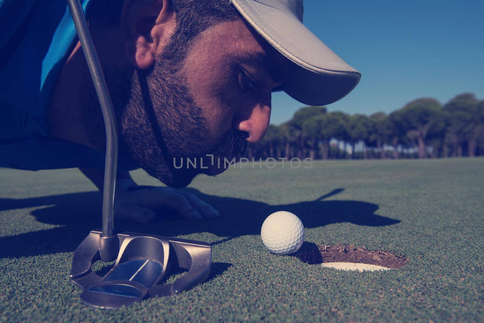 golf player blowing ball in hole. concept of cheating and success