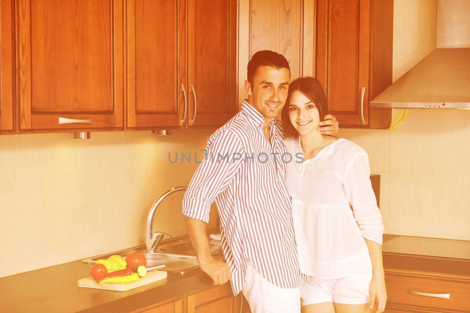 happy young couple have fun in modern kitchen by dotshock