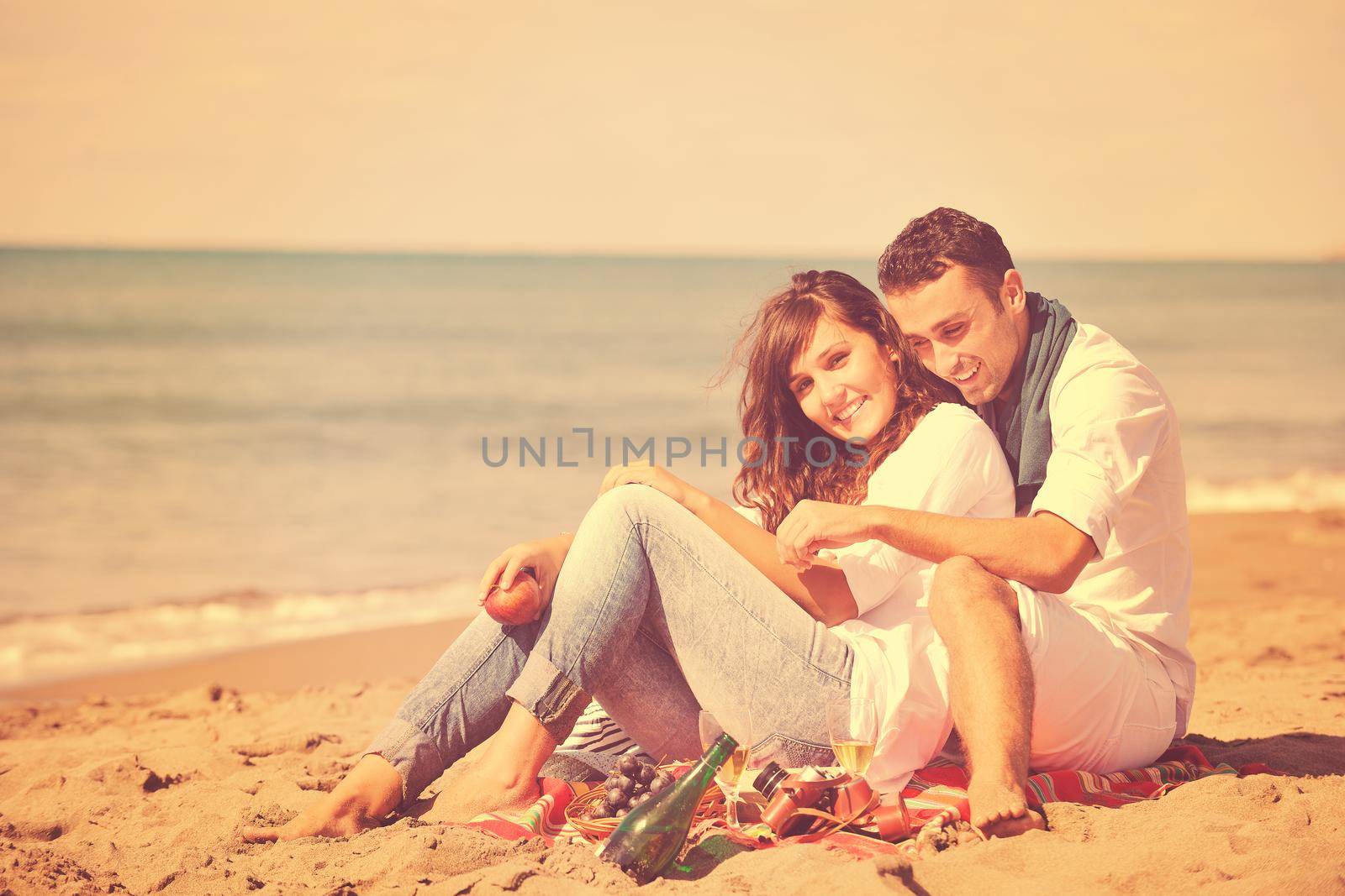 happy young couple enjoying  picnic on the beach and have good time on summer vacations