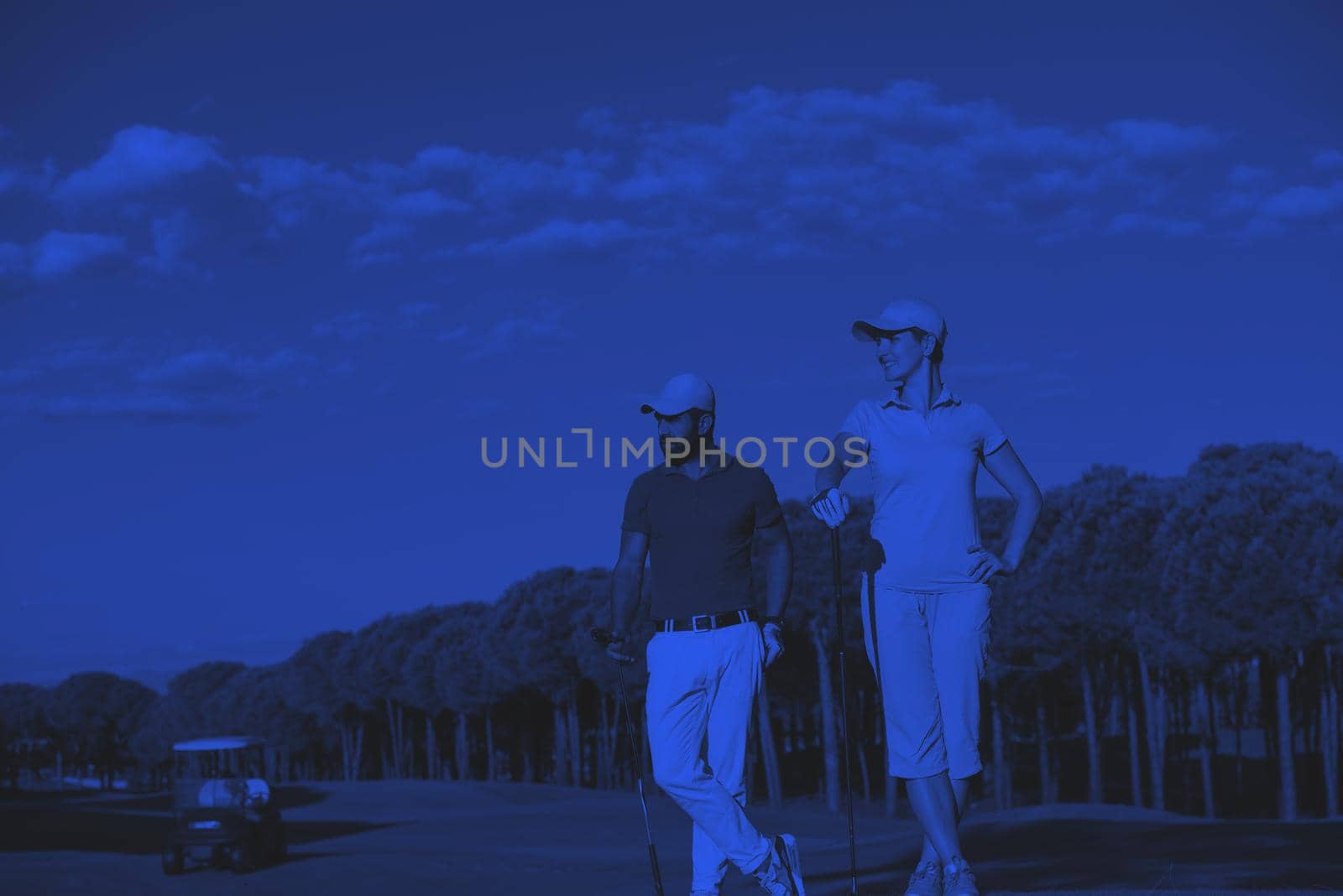 portrait of happy young  couple on golf course duo tone