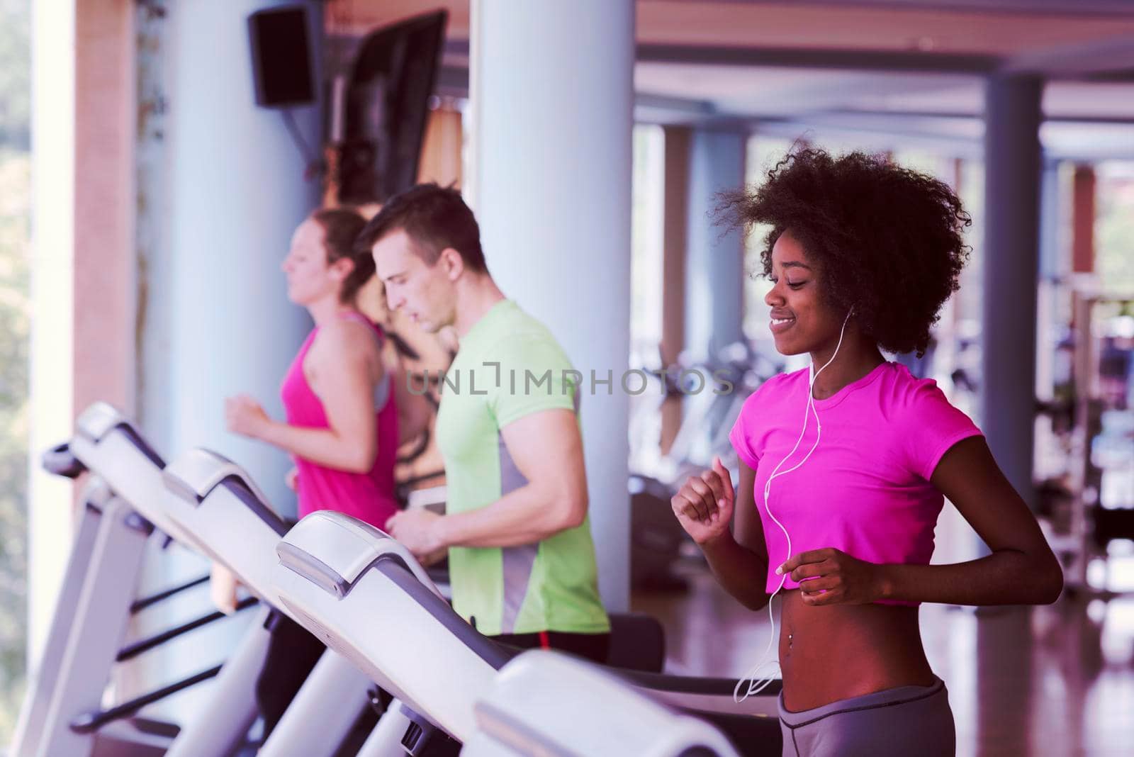 people exercisinng a cardio on treadmill in gym by dotshock