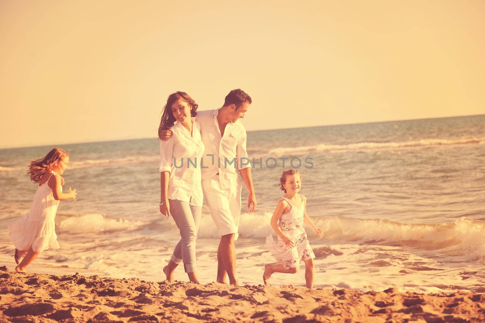 happy young family in white clothing have fun at vacations on beautiful beach 