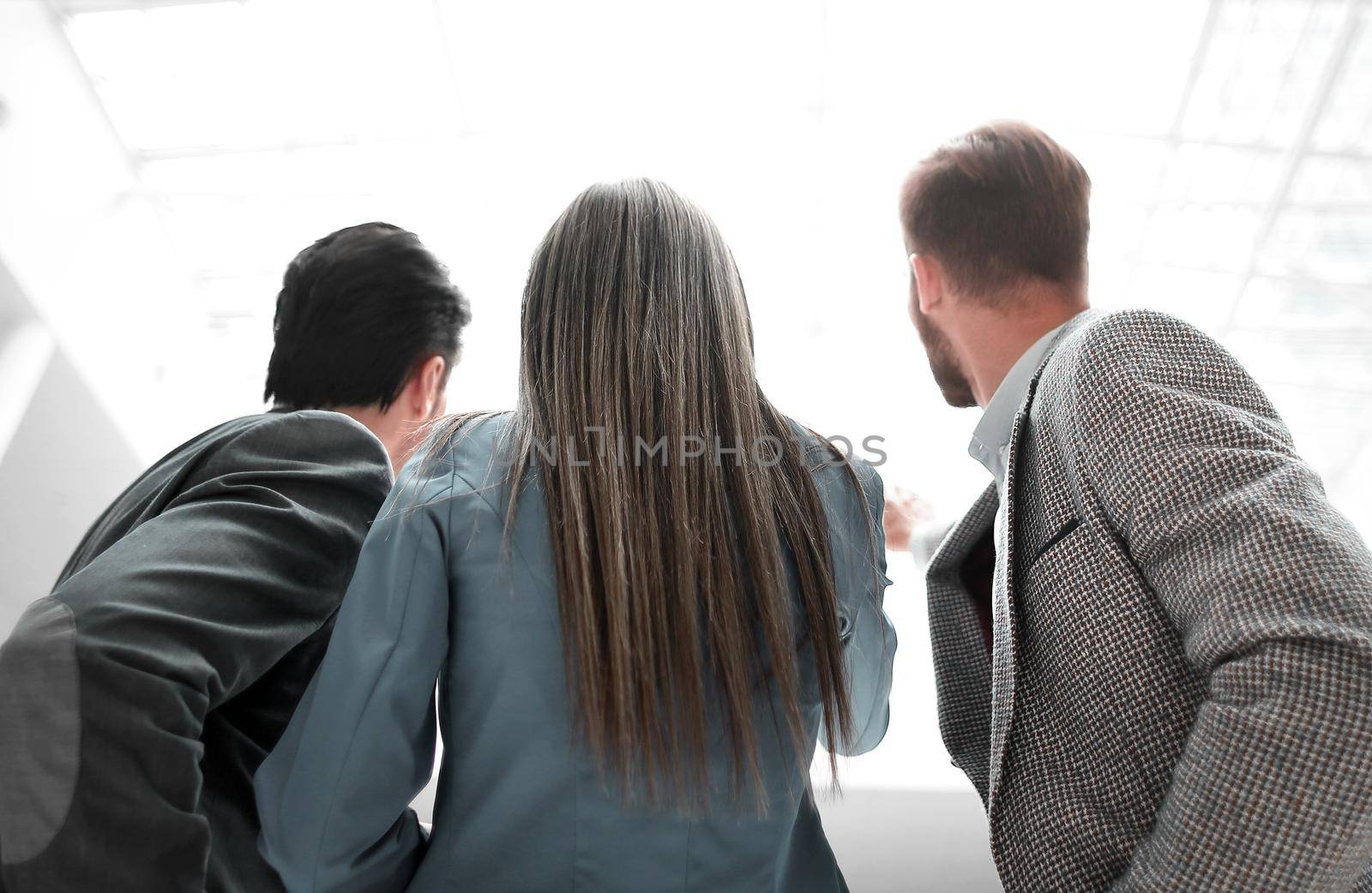 rear view.a group of business colleagues standing in the office by asdf