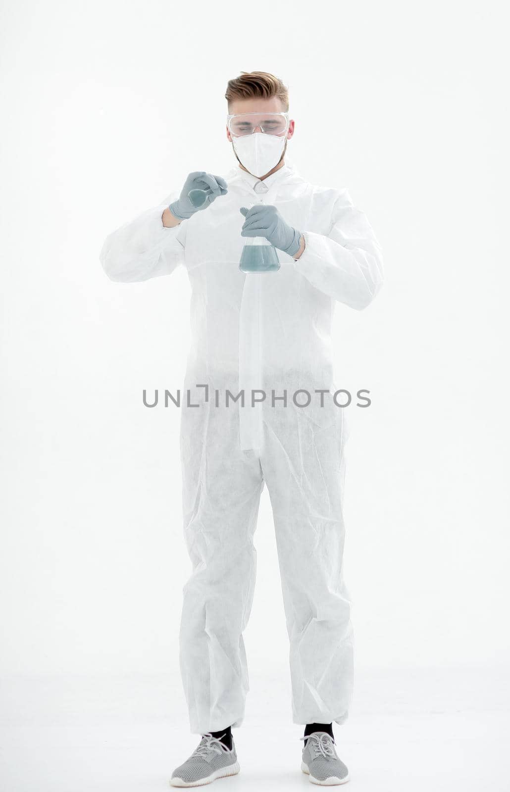 in full growth.a scientist in a protective suit examines the blue liquid.isolated on white