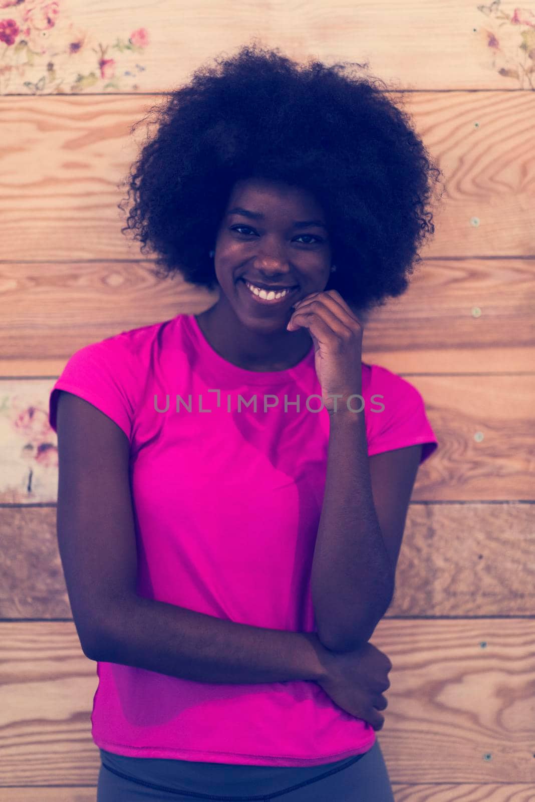 portrait of cute african american woman with afro hairstyle while  posing against old retro wooden background