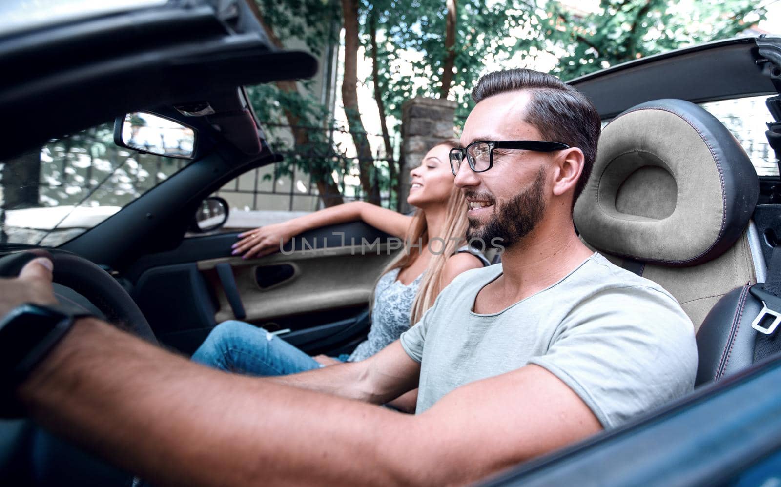 young man sitting behind the wheel of a luxury car. by asdf