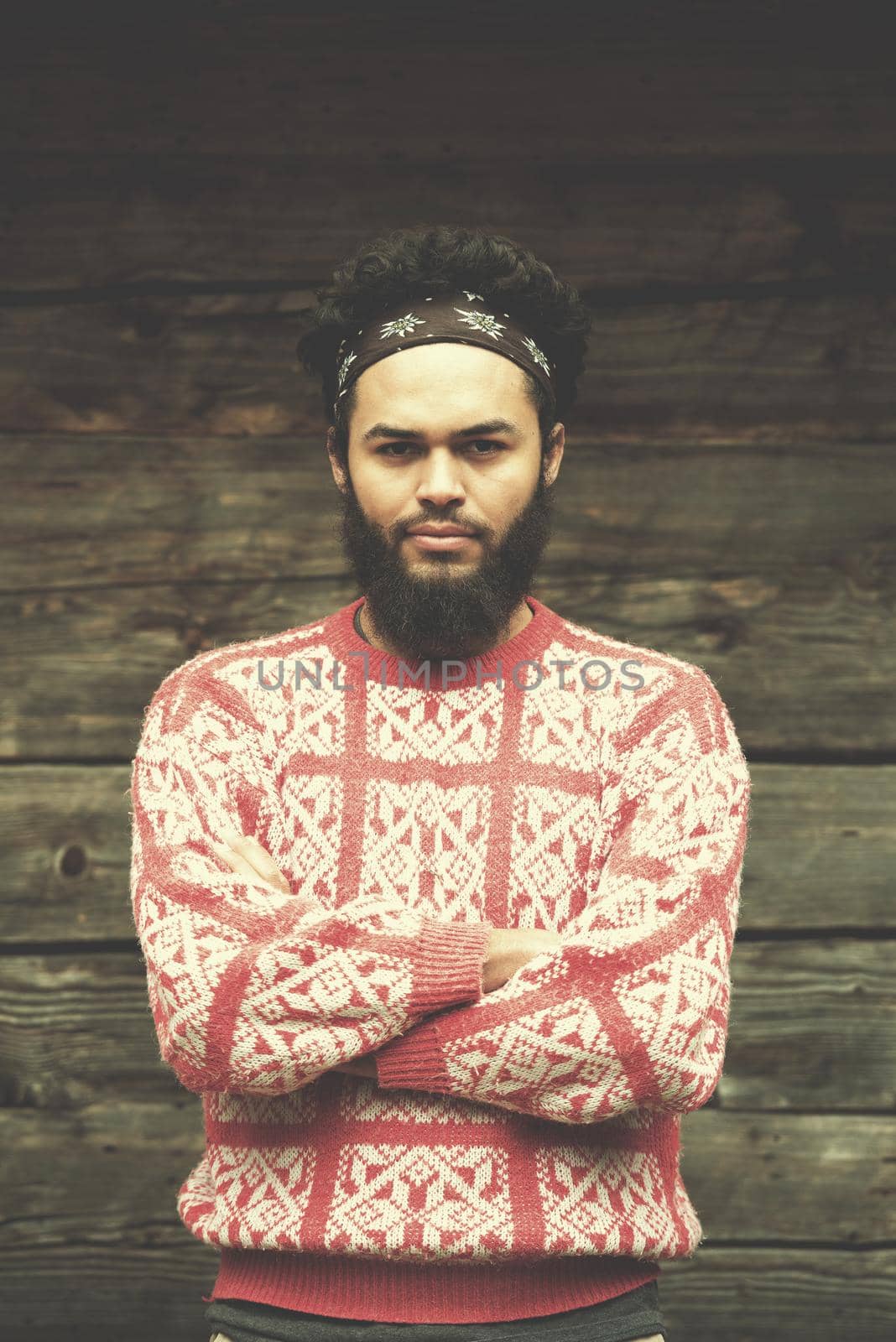 portrait of young hipster,  man with beard in front of old vintage wooden house