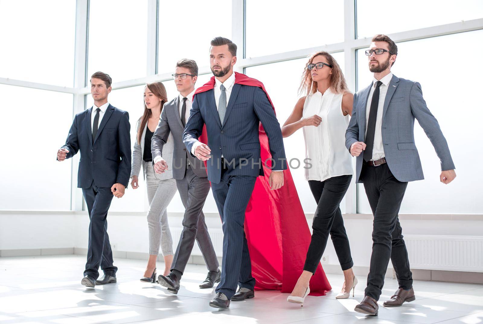 businessman in Superman cloak and business team standing in office lobby by asdf