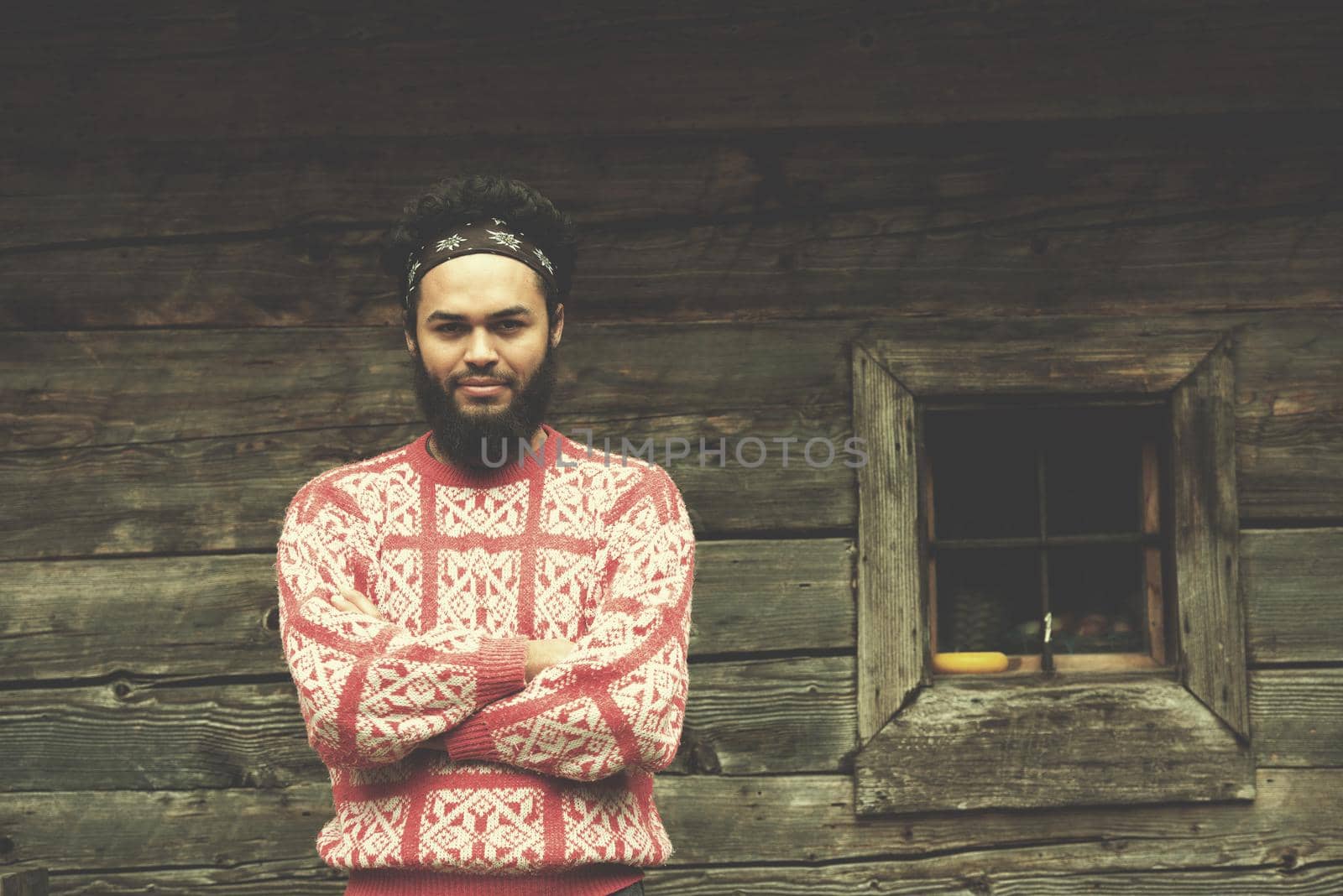 portrait of young hipster in front of wooden house by dotshock