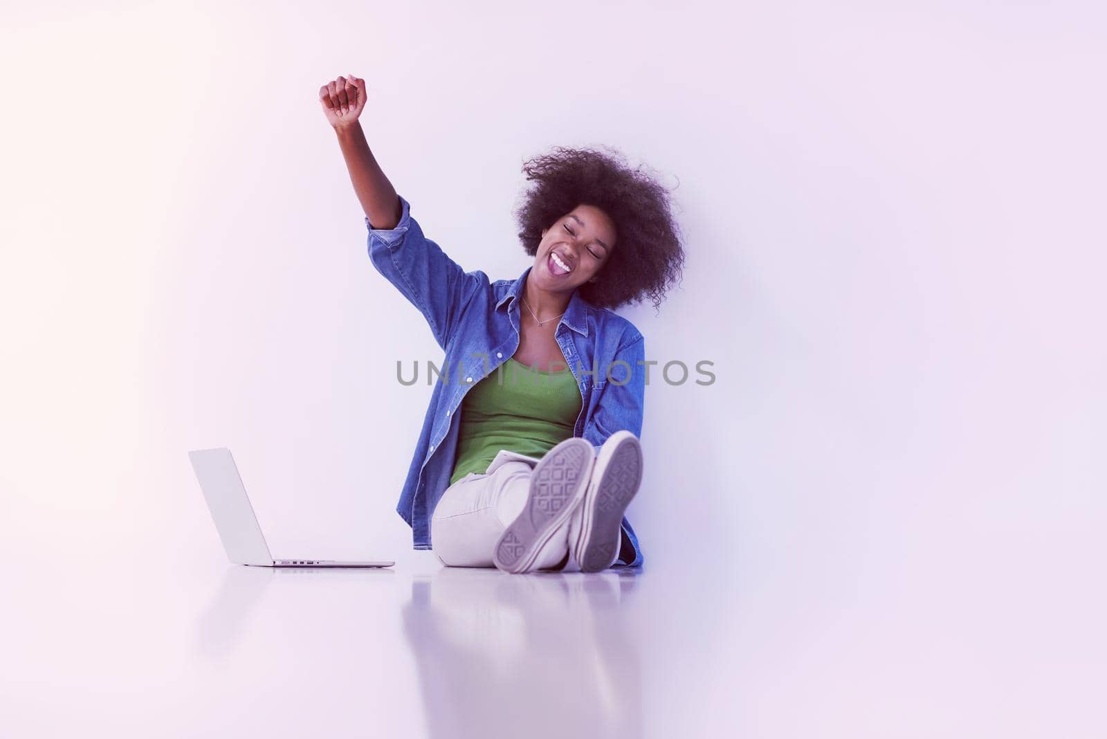 Portrait of happy young african american woman sitting on floor with laptop