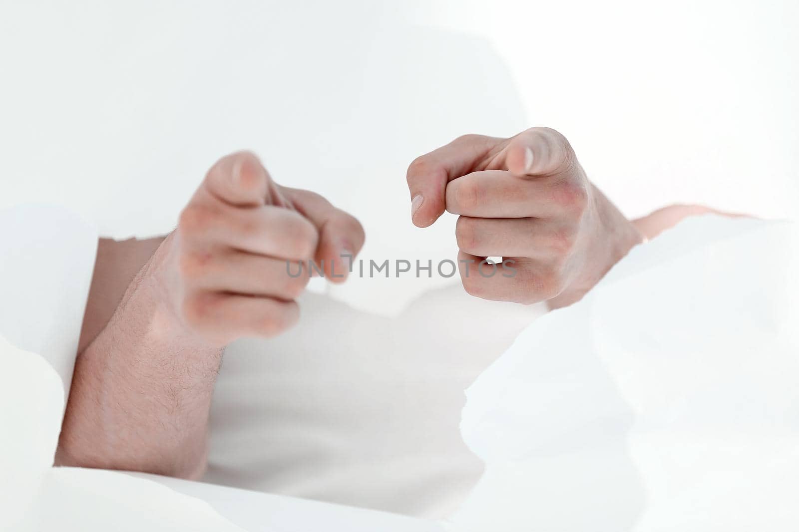 man is breaking through a paper wall and pointing at you.photo with copy space