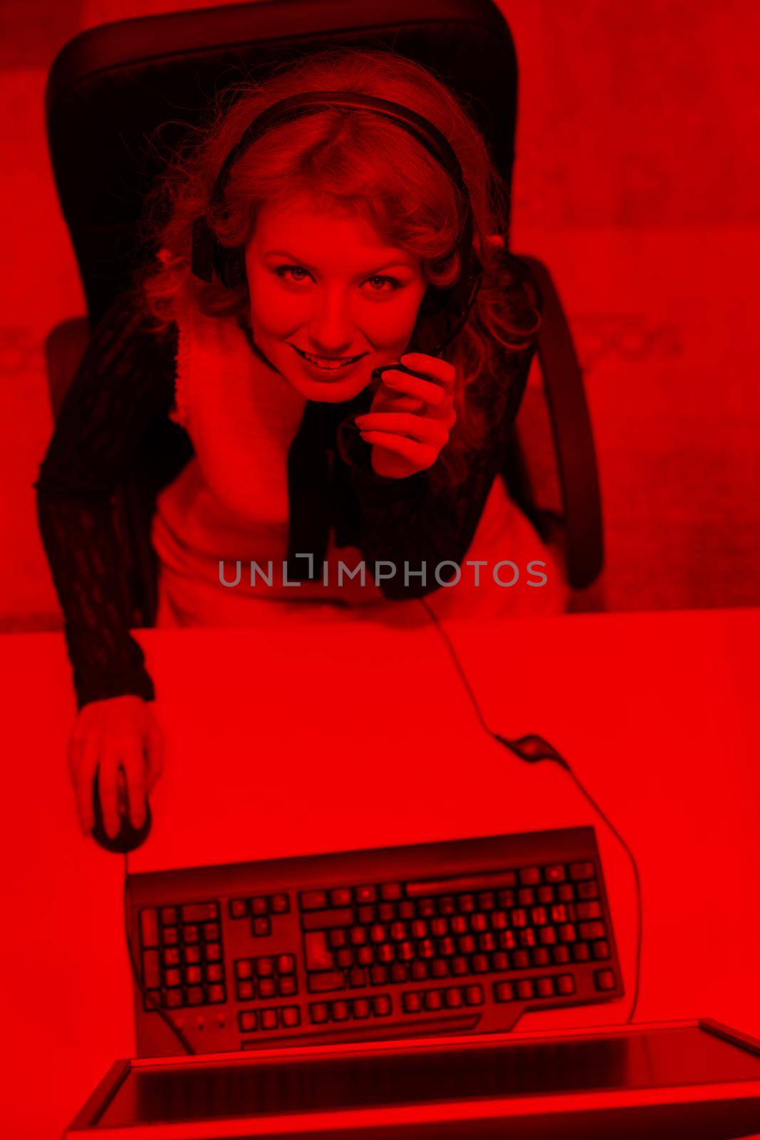 top view of a young smiling female call centre operator doing her job with a headset