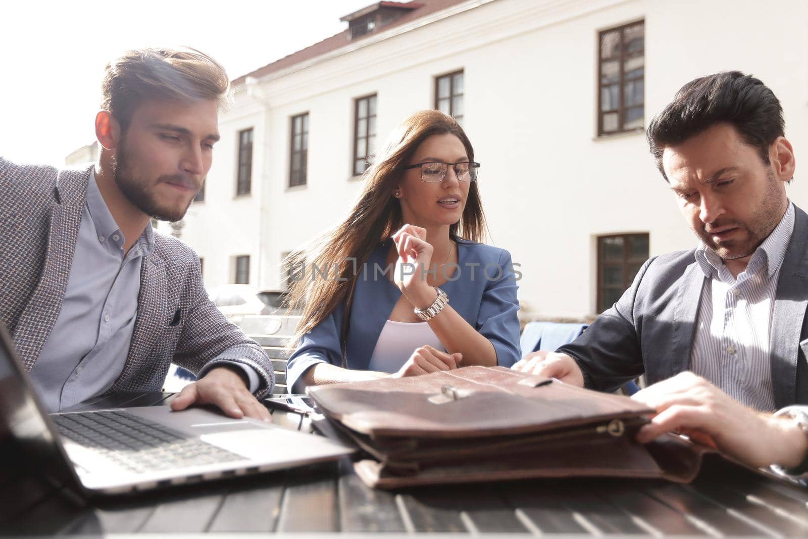 business partners sit at a table on the street, by asdf
