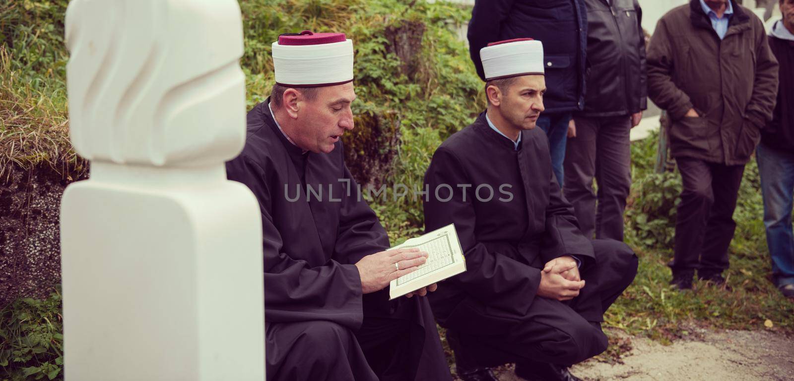 quran holy book reading by imam  on islamic funeral with white thumb stones graweyard background