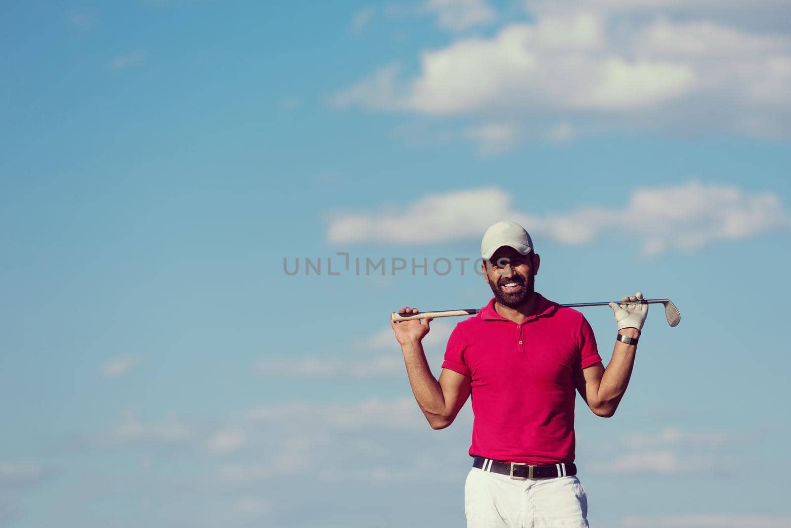 handsome middle eastern golf player portrait at course at sunny day wearing red  shirt