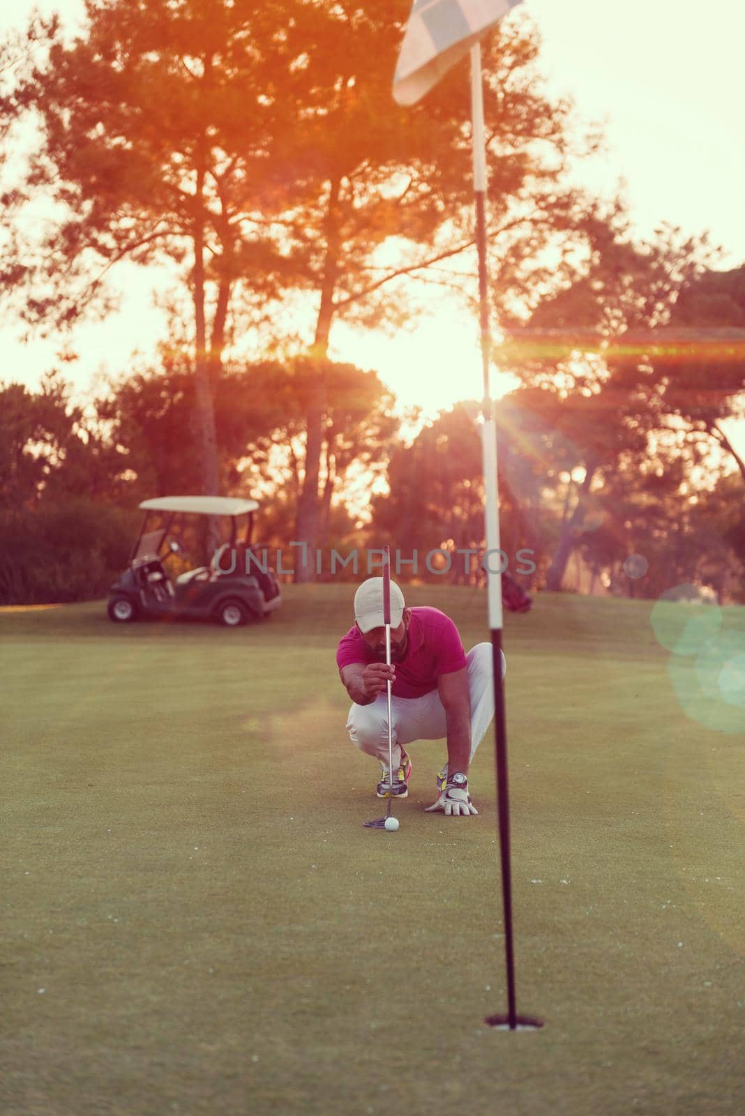 golf player aiming perfect  shot on beautiful sunset by dotshock