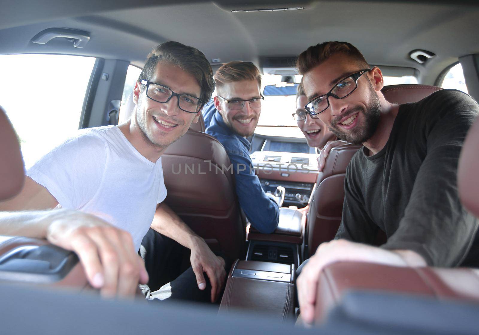 close up. a group of friends sitting in the car and looking at the camera