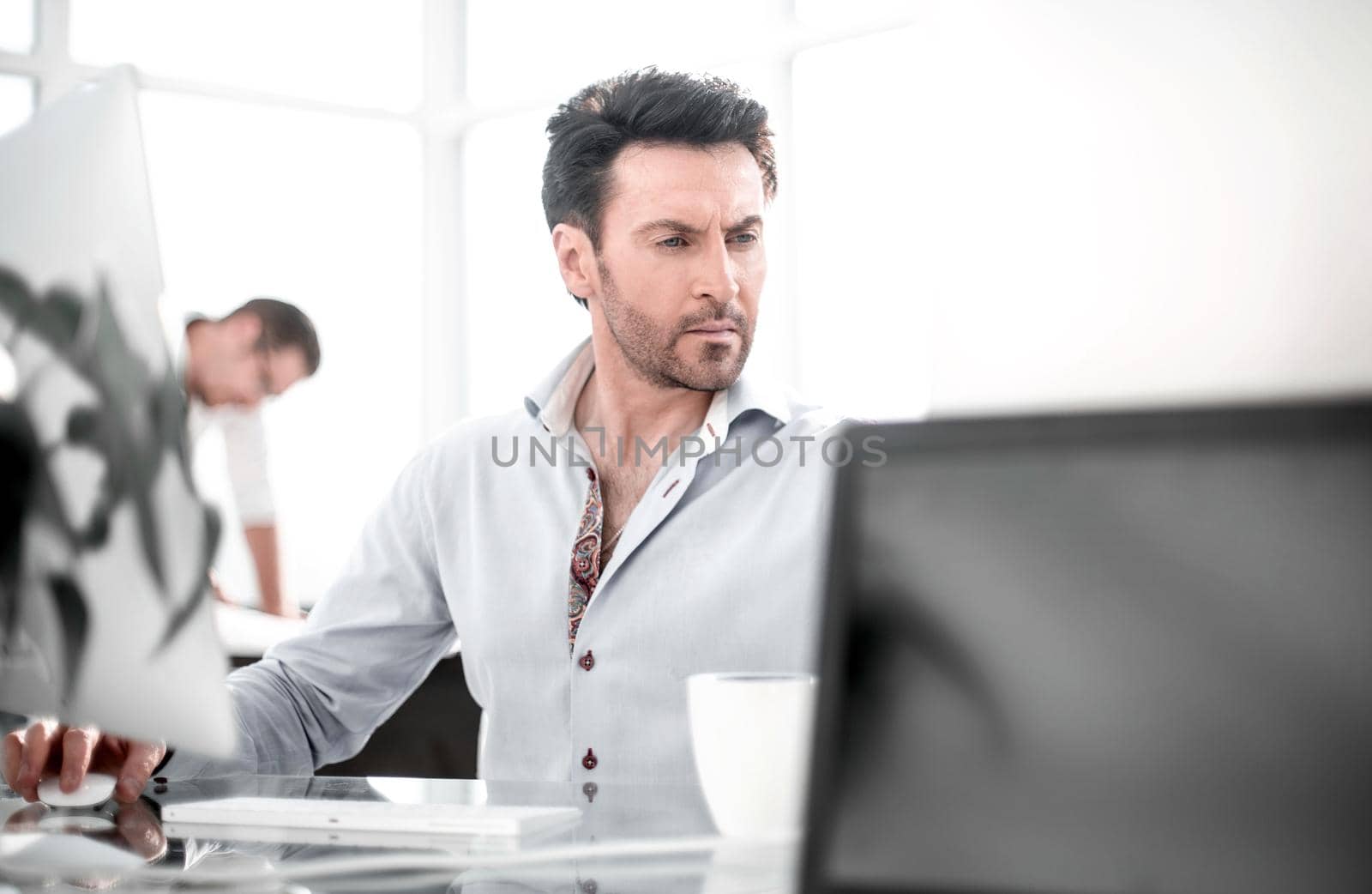 business man talking to a colleague sitting at his Desk. office weekdays