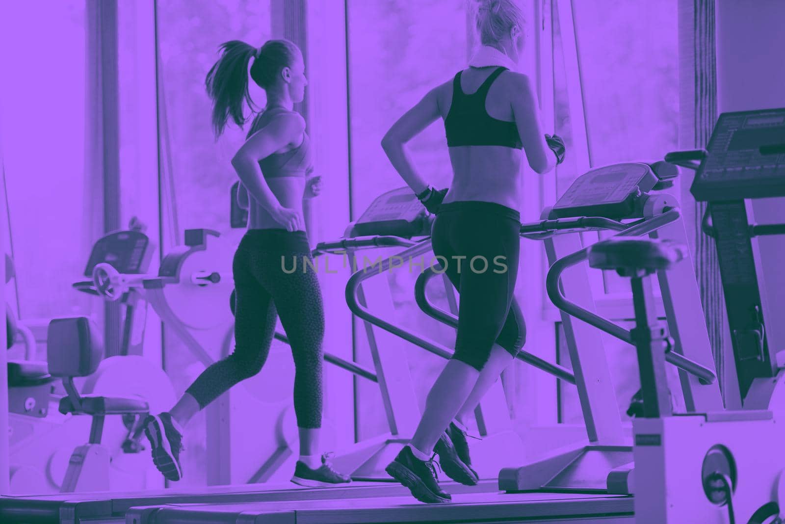 woman exercising on treadmill in gym by dotshock