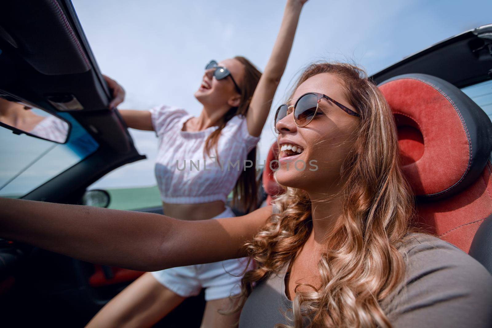 close up.happy young women driving a convertible car.summer holidays, travel, vacation, travel