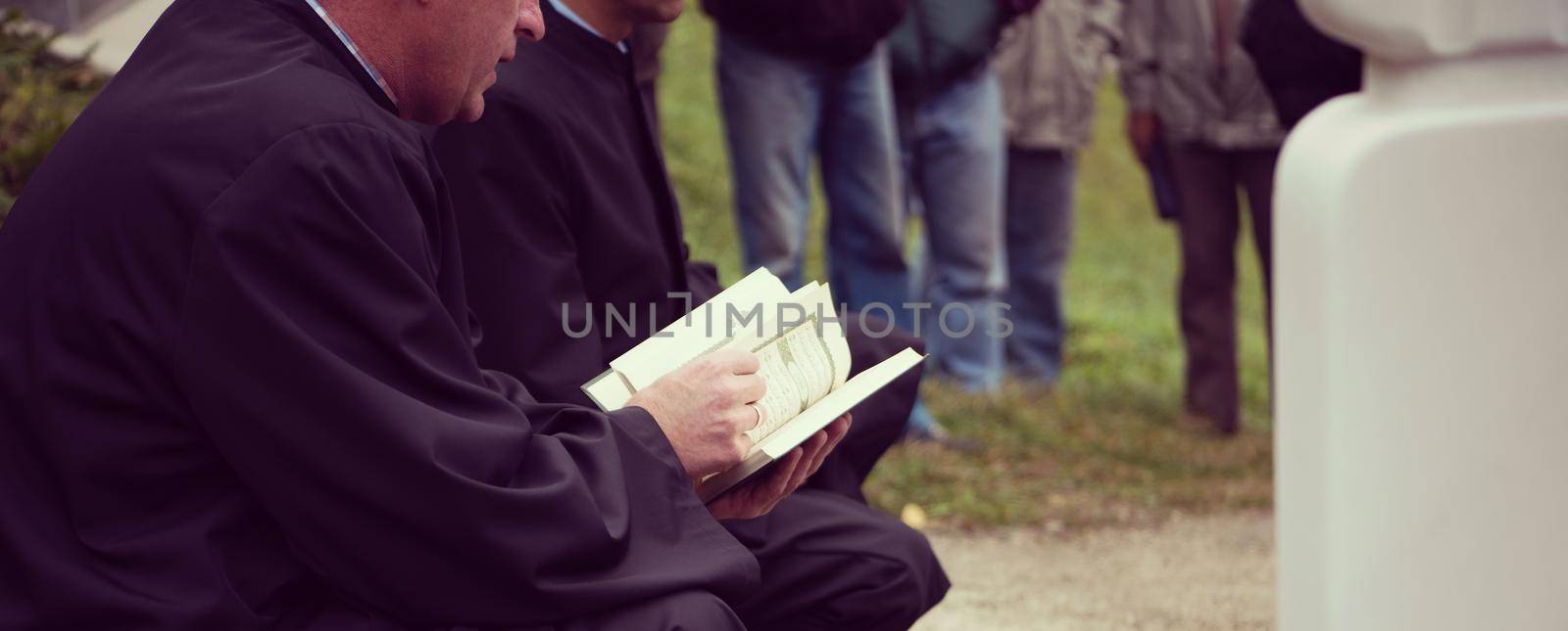 quran holy book reading by imam  on islamic funeral with white thumb stones graweyard background