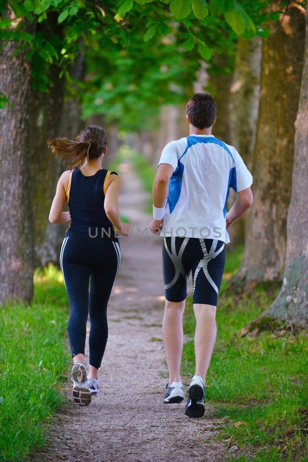 Young couple jogging in park at morning. Health and fitness.