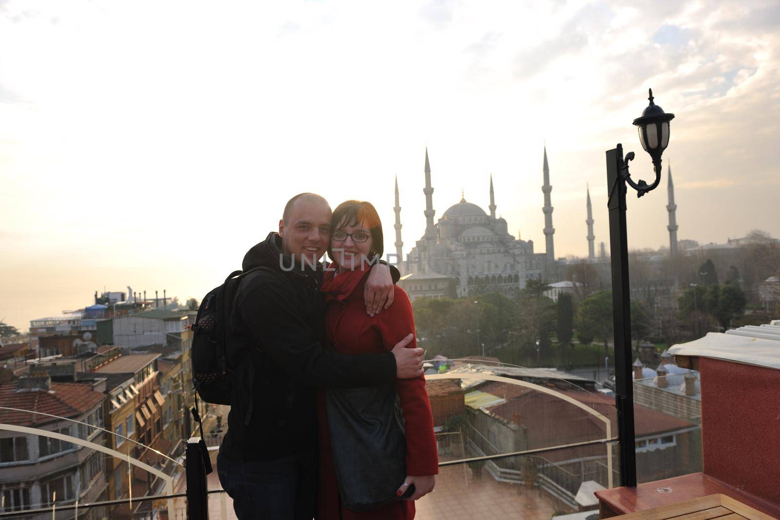 happy young couple portrait outdoor at sunny day in istanbul turkey with beautiful old mosque with sunset in background