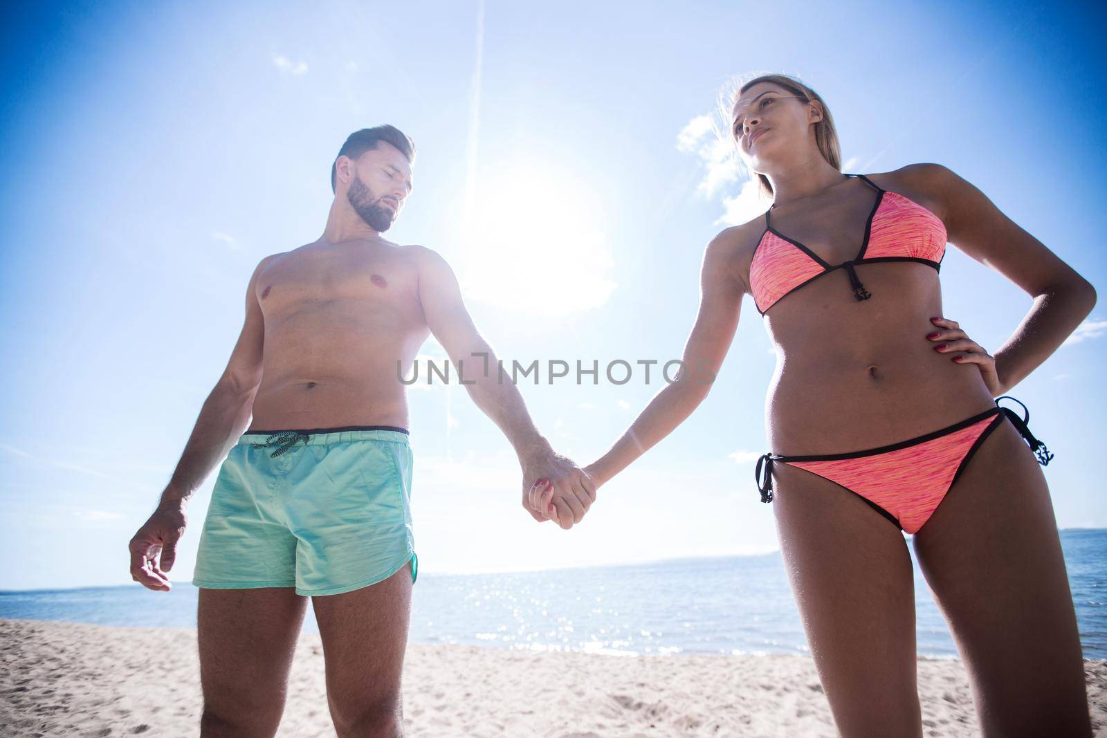 Couple on the Beach in Swimwear Holding Hands by asdf