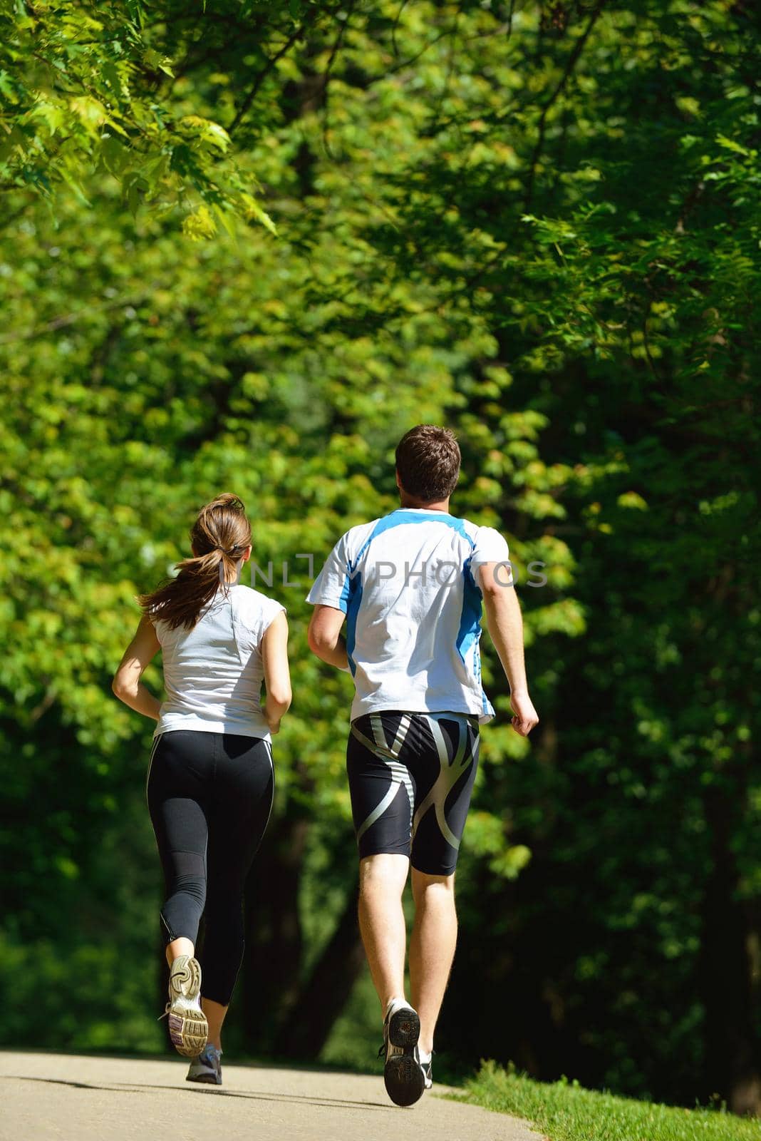 Young couple jogging in park at morning. Health and fitness.