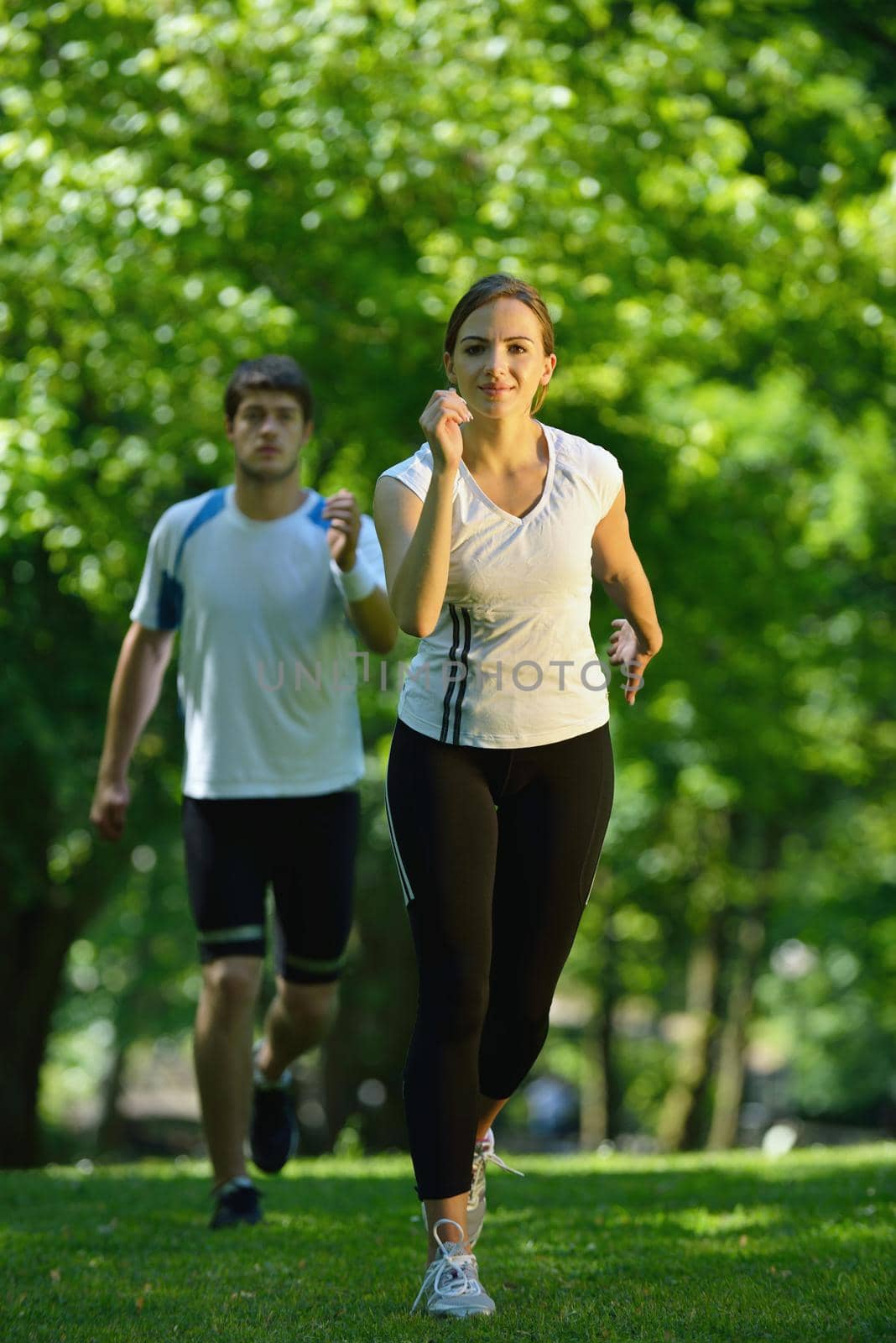 Young couple jogging in park at morning. Health and fitness concept