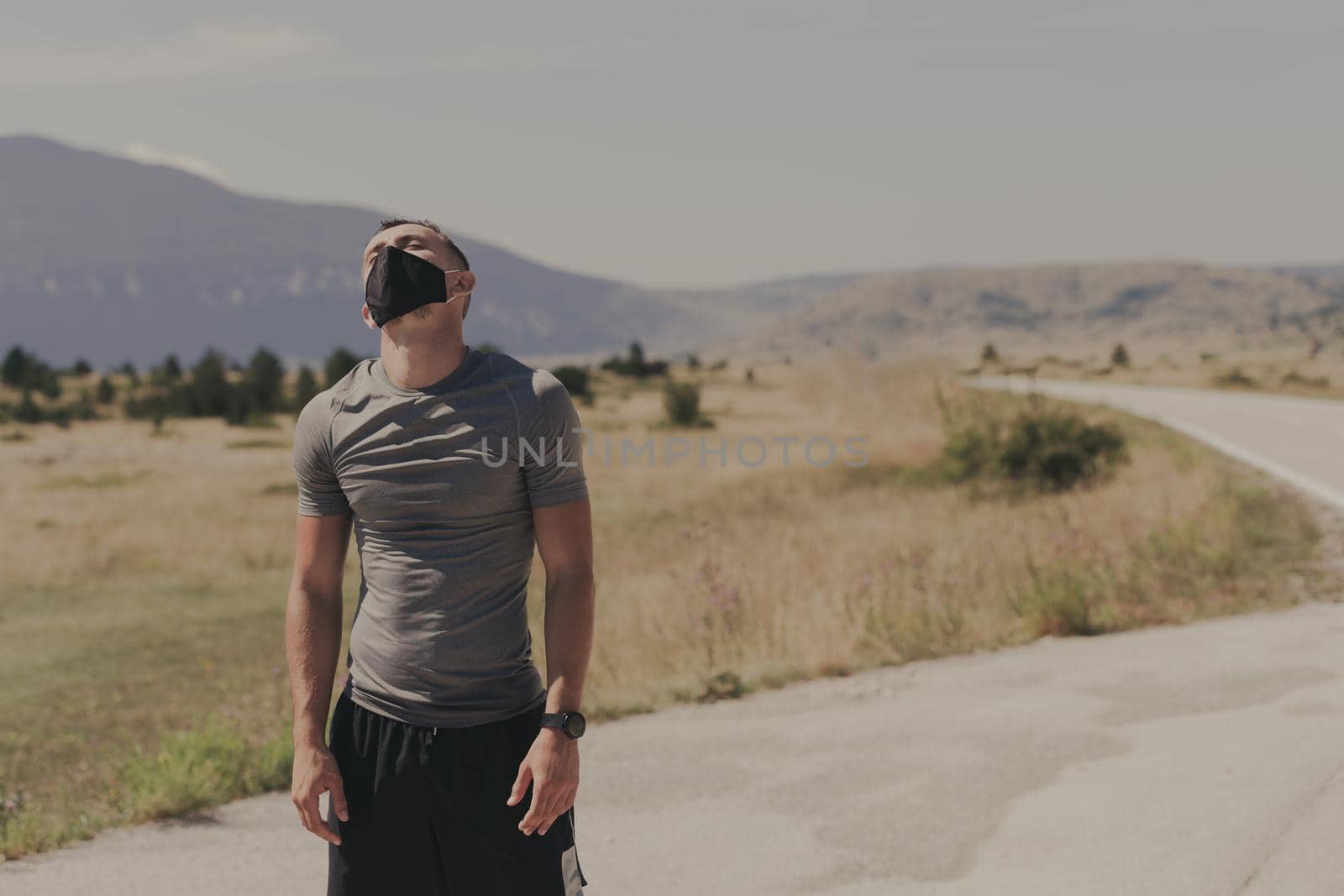 Young man and woman in protective masks running and doing exercises outdoors in the morning. Sport, Active life Jogging during quarantine. Covid-19 new normal. High quality photo. Selective focus. by dotshock