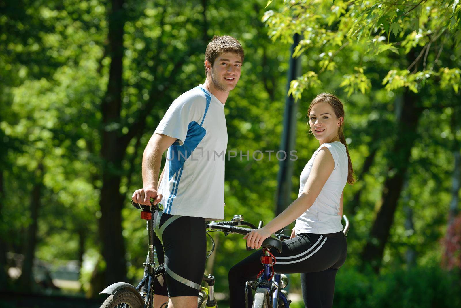 Happy couple riding bicycle outdoors by dotshock